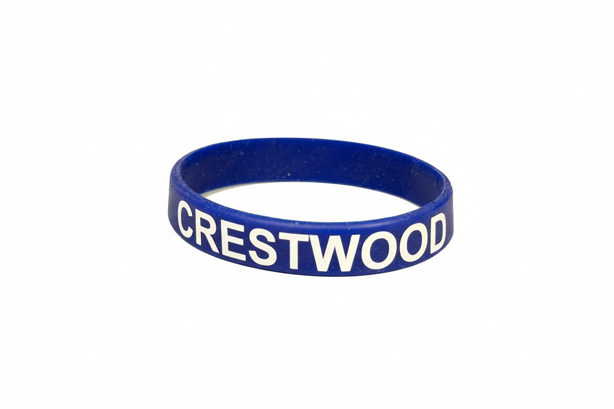 Blue wristband with 'CRESTWOOD' printed on it on a reflective surface.